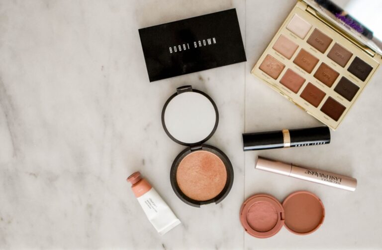 Flat lay image of essential makeup items representing how to apply makeup in your 30s