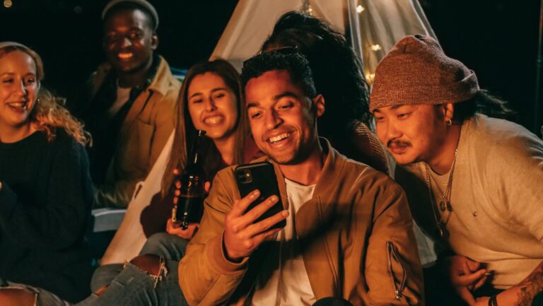 Man Showing His Mobile Phone to His Friends