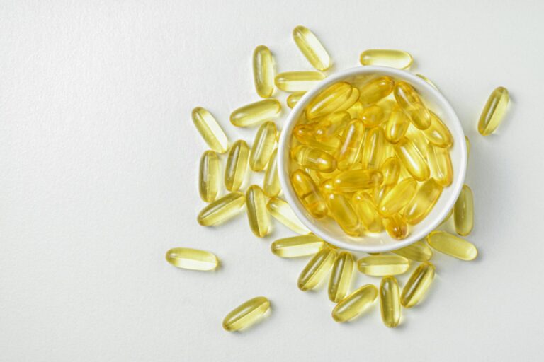 Flat lay of Fish oil gold capsule on background. Food supplement. Vitamin D. Vitamin E. Omega 3.