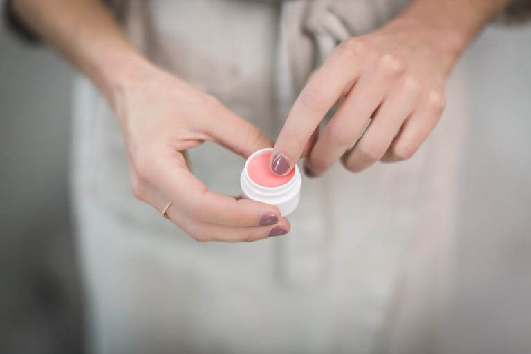 Person Holding Cream Container