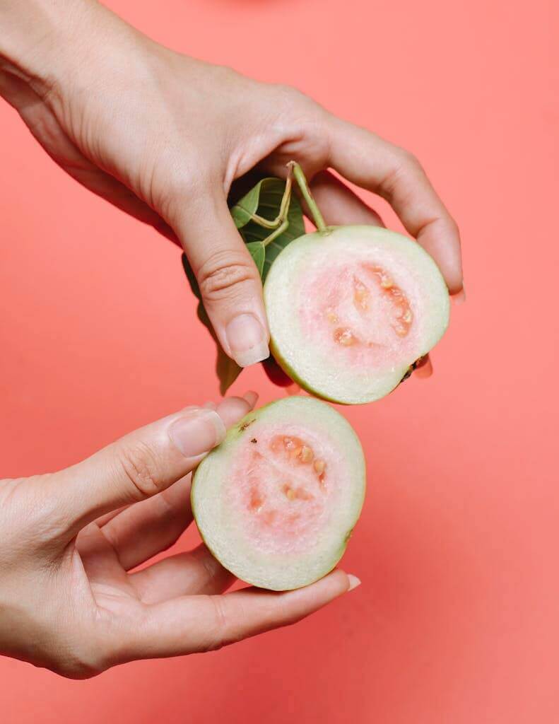 Crop woman with halves of guava