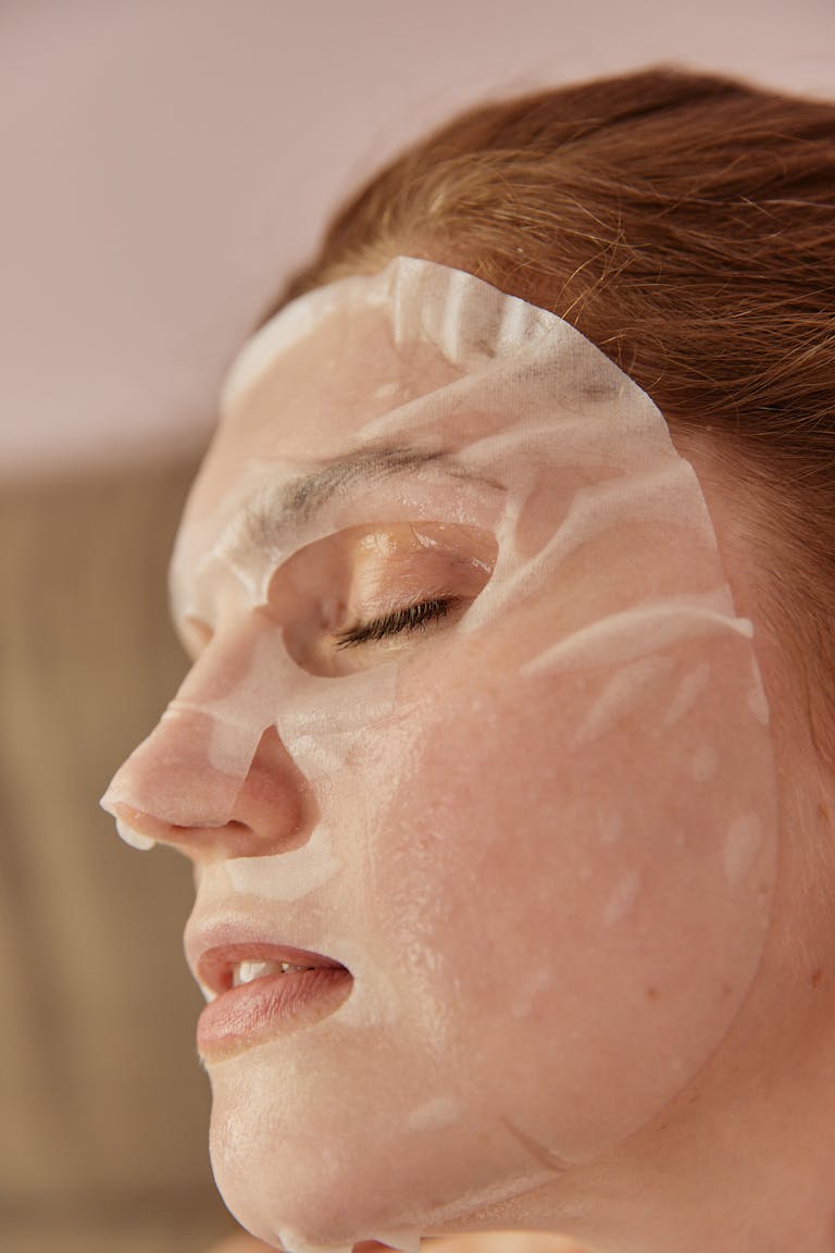 A Close-up Shot of a Woman with a Sheet Mask on Face